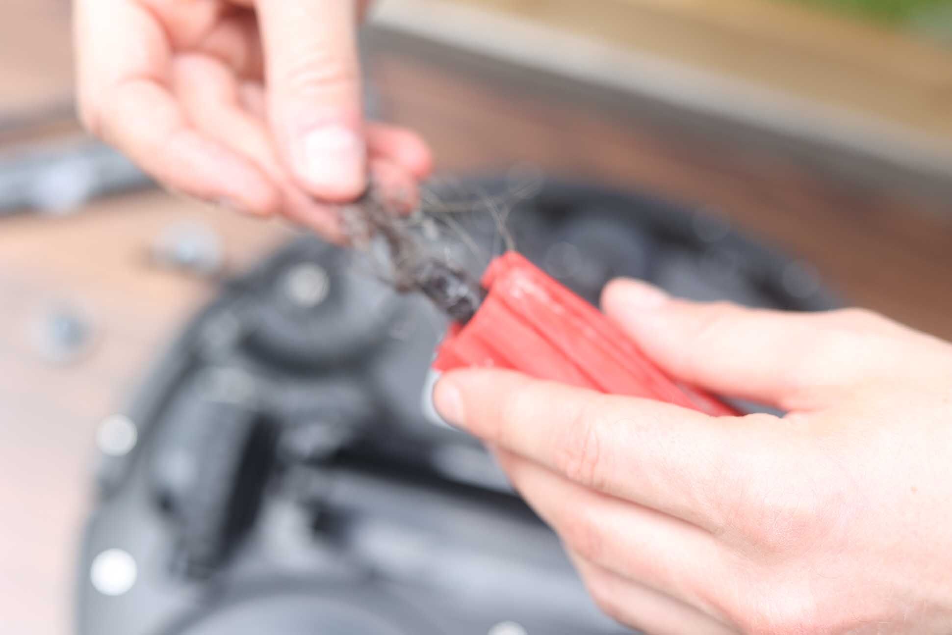 Волосы удаляются с основной щетки с помощью ножниц.